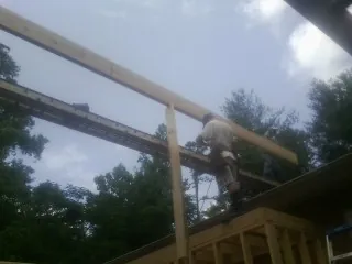 Carpenter setting a ridge beam over a new addition frame — Ice Dam Removal by Roofing Brothers in Mount Clemens