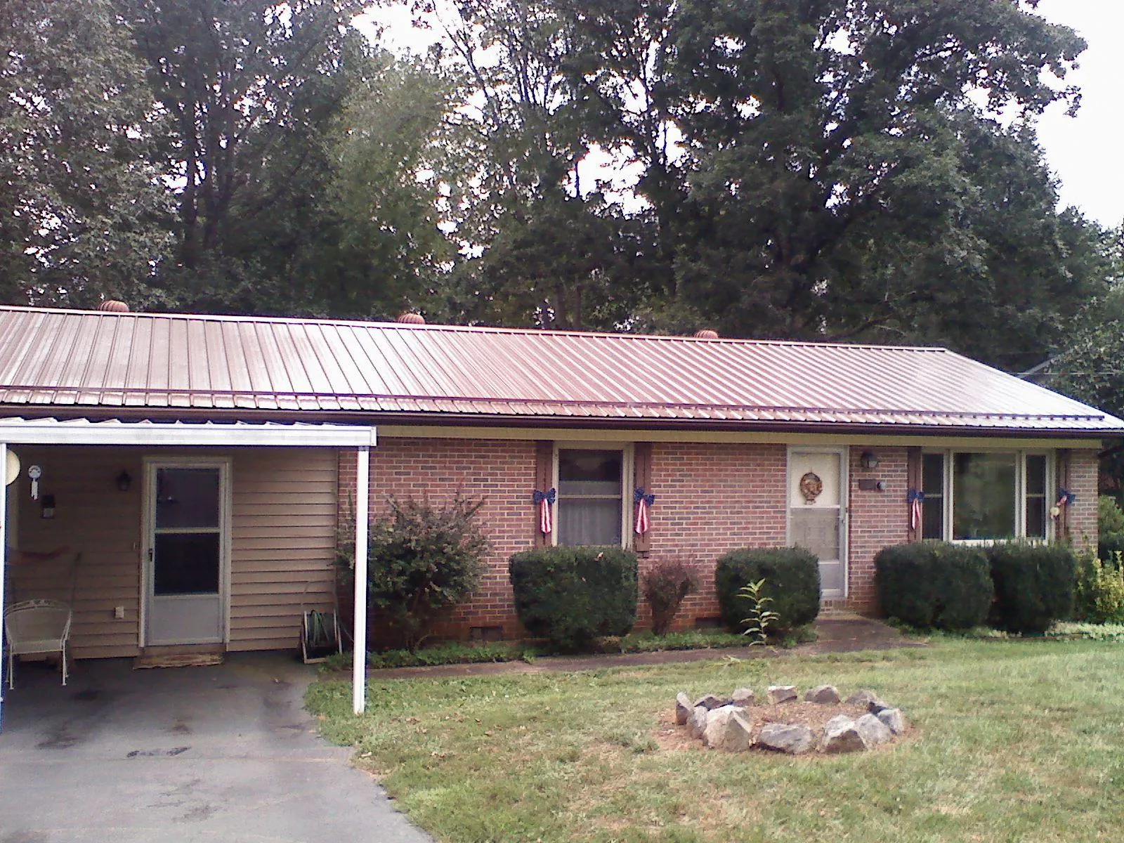Bronze metal roof and carport on a brick ranch home — Roof Repair work by our crew in Mount Clemens